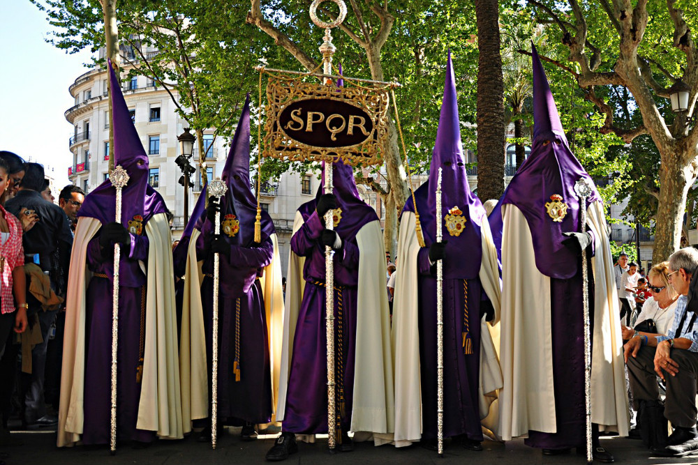 Nazarenos with insignia in the procession of the Holy Week in Seville