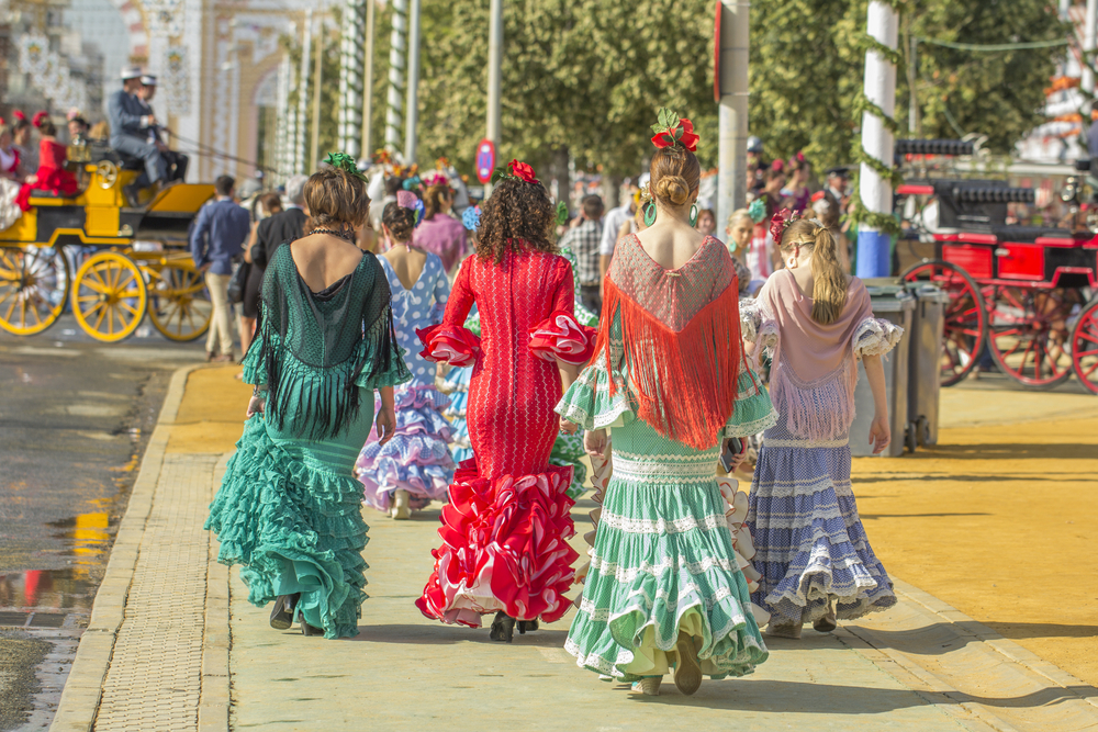 Women in typical dresses during fair in Seville