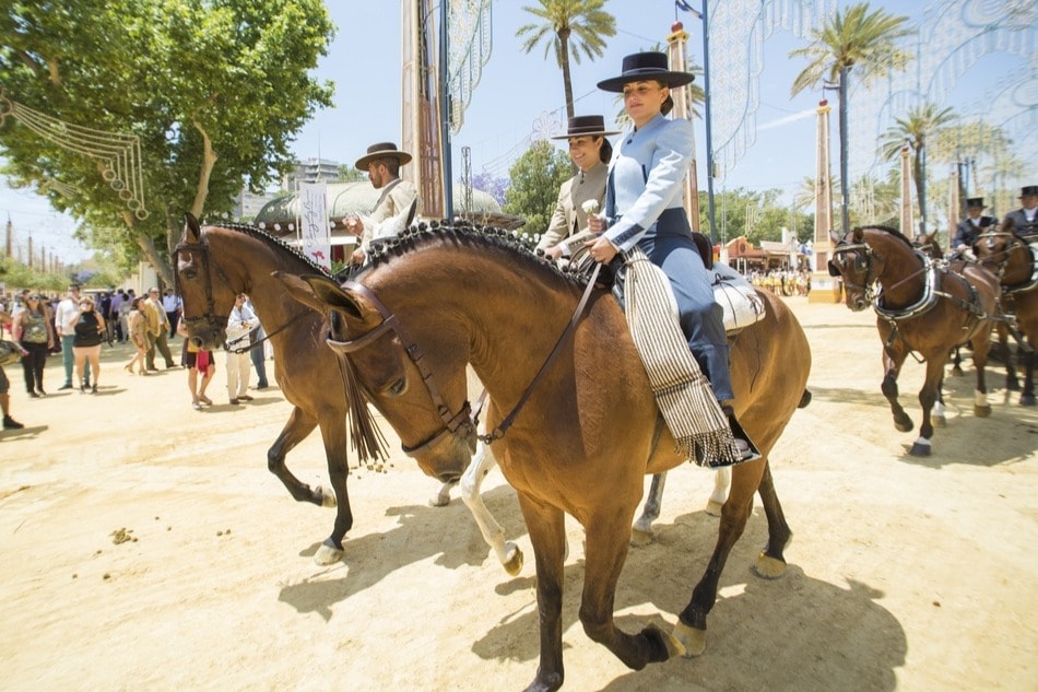 Ruiters en paarden rijden tijdens de paardenmarkt in Jerez