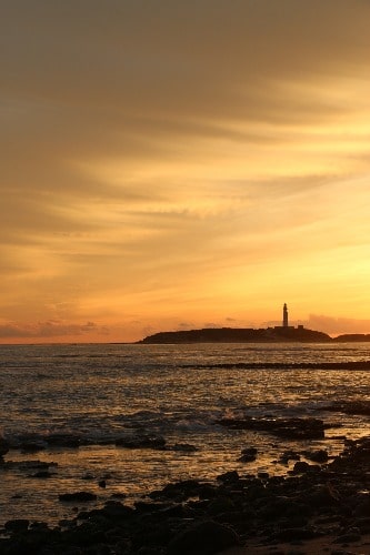 Vuurtoren van Trafalgar aan de horizon bij zonsondergang